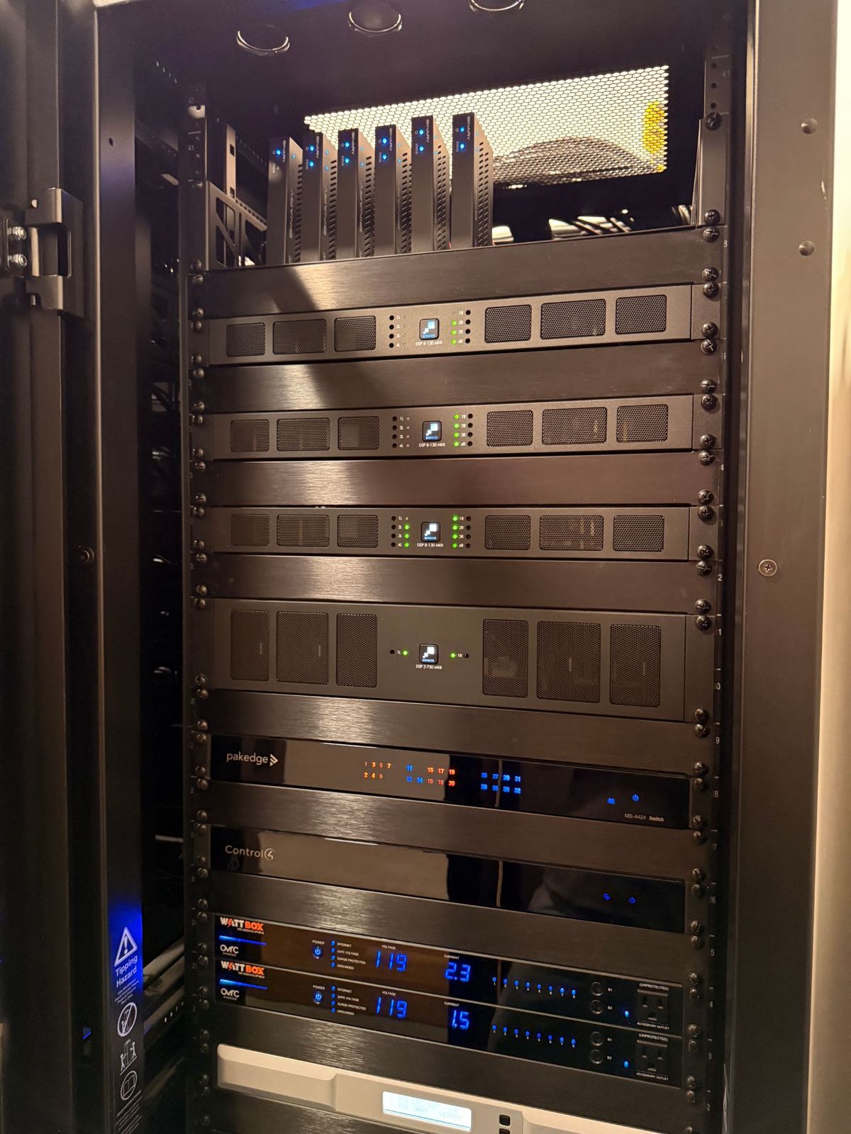 The front of a finished equipment rack with Sonance amplifiers, network switch, Control4 controller, and WattBox power